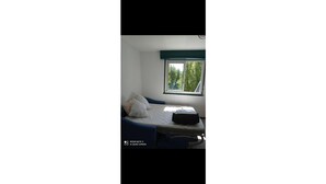 A room with a bed, a window, and a bed frame. - Apartment close to the beach (Houlgate)