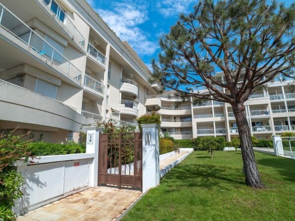 A multi-story residential building with balconies, a gated entrance, and a well-maintained lawn. - Royal Palm by Interhome (Cannes)