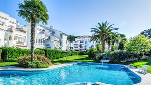 A swimming pool with a hot tub, surrounded by a well-maintained garden and residential buildings. - Golf Royal Omega by Interhome (Pals)