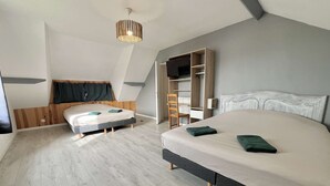 A modern bedroom with two beds, a built-in wardrobe, and a ceiling light fixture. - House (Asnelles)