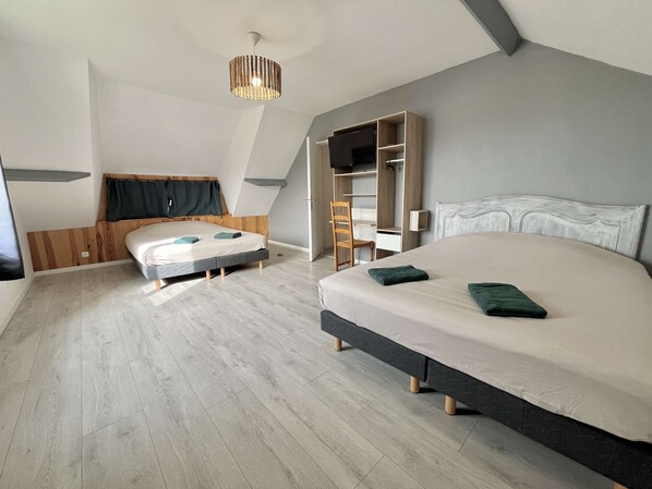 Ein modernes Schlafzimmer mit zwei Betten, einem eingebauten Kleiderschrank und einer Deckenleuchte.