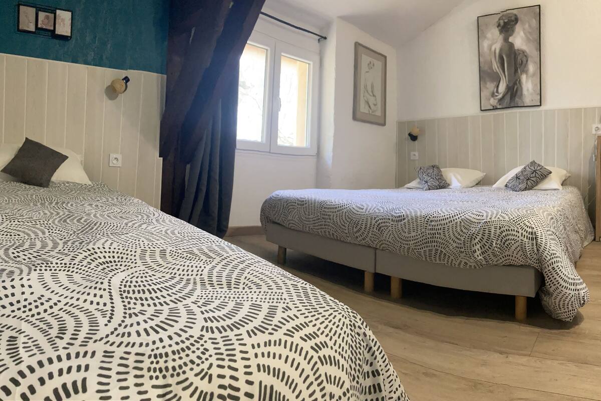 Une chambre avec deux lits, un bureau et une chaise.