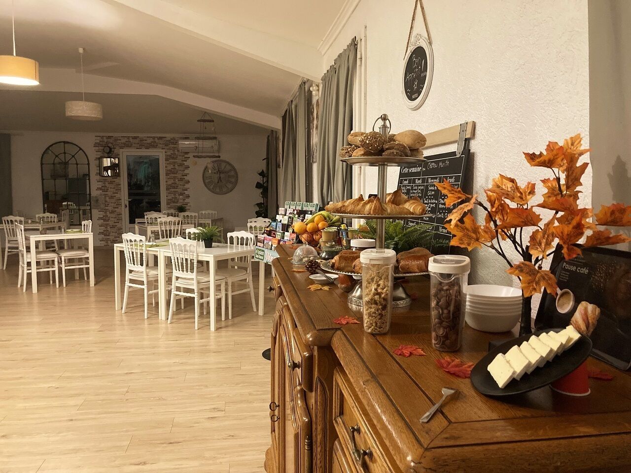 A café with a wooden counter, white chairs, and a menu board.