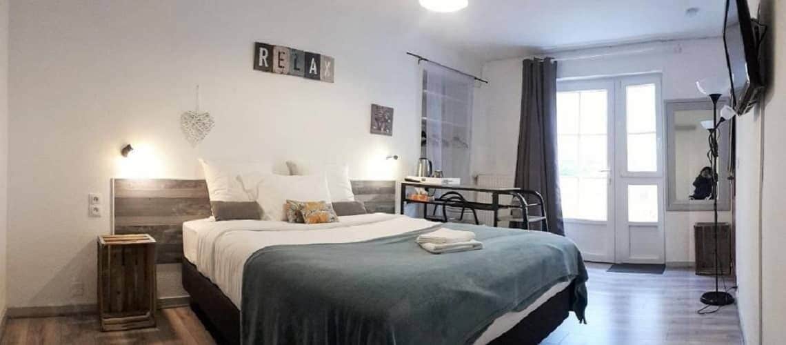 Une chambre à coucher avec un lit, des tables de chevet, un bureau et une chaise.