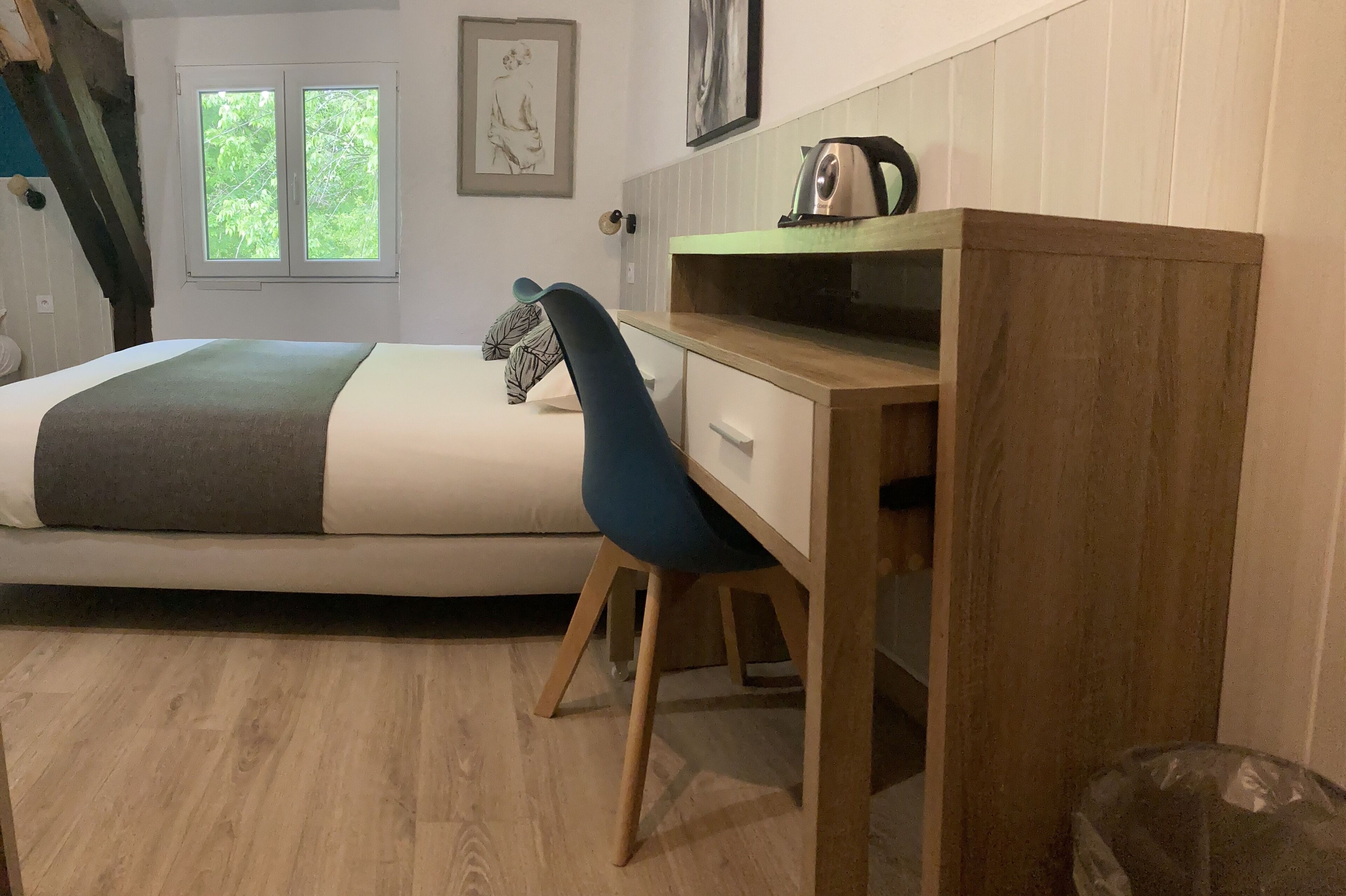 Une chambre à coucher avec un lit, un bureau, une chaise, une fenêtre et une porte.