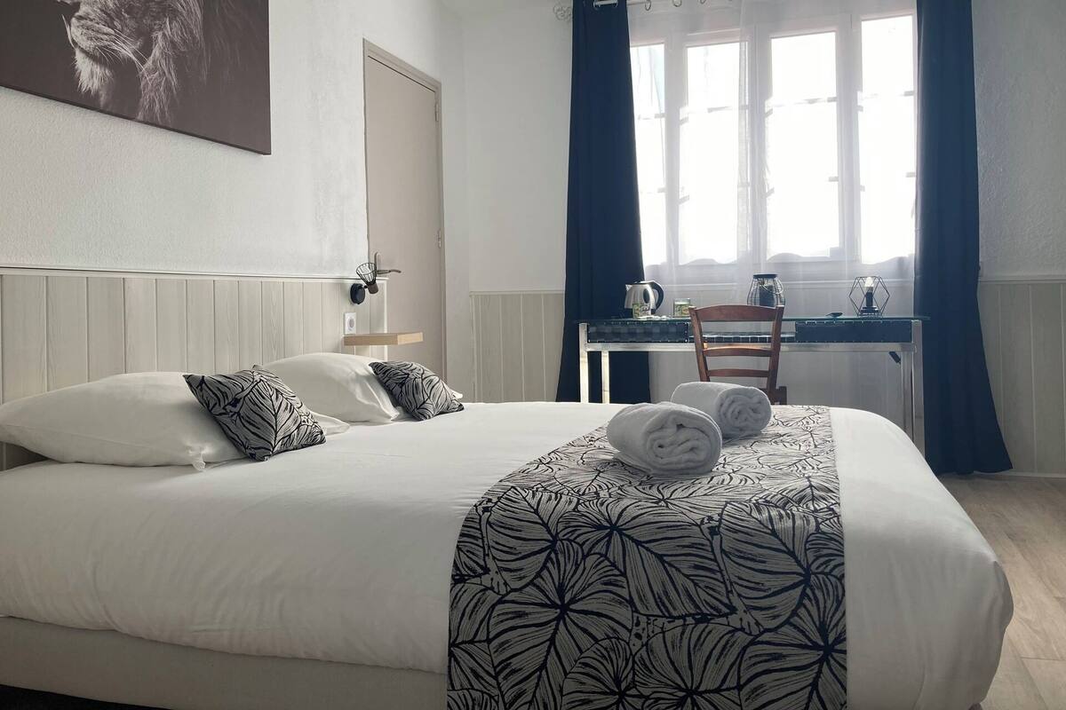 Une chambre d’hôtel avec un lit, un bureau et une chaise.