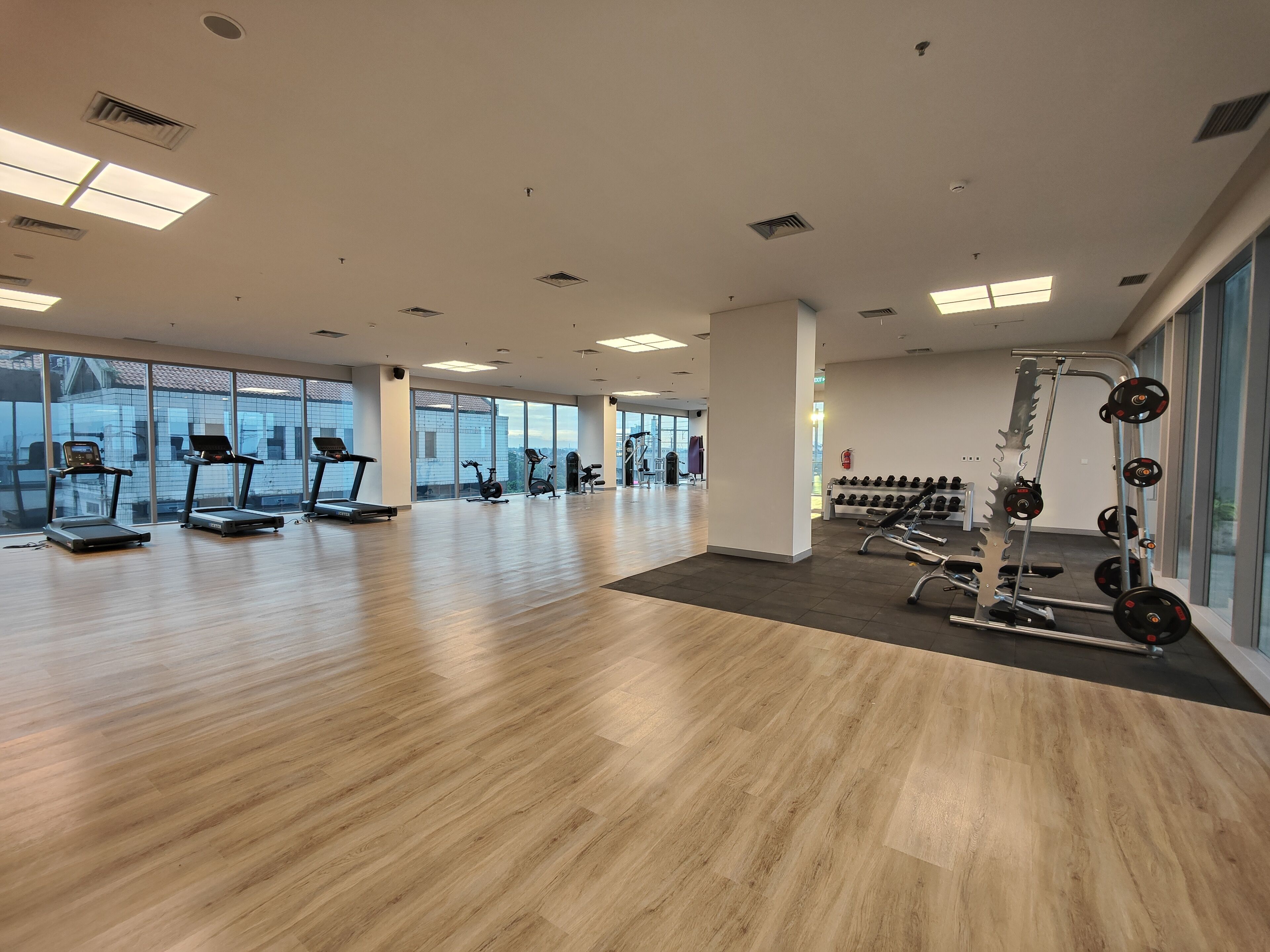 A spacious gym with treadmills, stationary bikes, and weightlifting equipment.