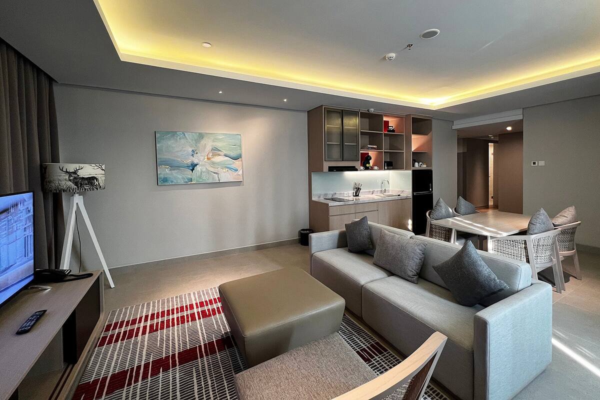 Una sala de estar moderna con un sofá, una mesa de comedor y una zona de cocina.