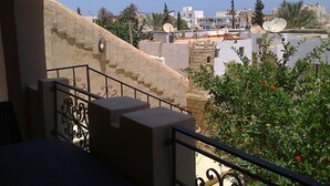 A balcony with a view of a residential area, including buildings and satellite dishes.