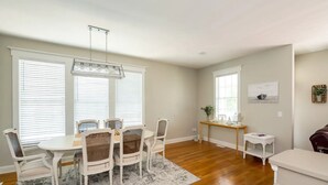 A dining area with a round table and six chairs, a small side table, and a bench. - The Queen B (Oak Island)
