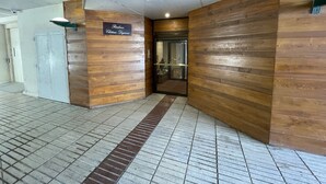 A hotel entrance with a wooden facade and a tiled floor. - Beautiful 1-bedroom apartment near the beach, with parking and garage (Arcachon)