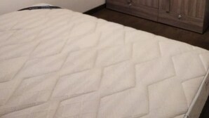 Ein Schlafzimmer mit einem Bett, einem Holzschrank und einem Nachttisch.