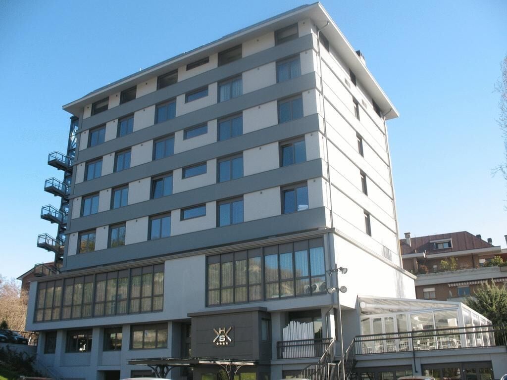 A multi-story hotel with a modern design, featuring a prominent logo on the facade.