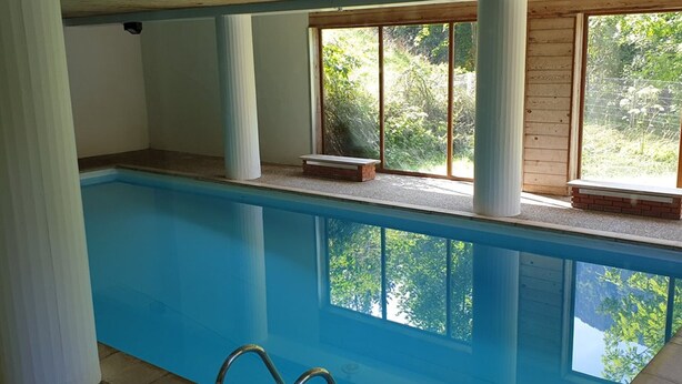 An indoor swimming pool with clear views of greenery outside. - Studio 28m² with pool, balcony, parking - St-Jean-d'Aulps (Saint-Jean-d'Aulps)