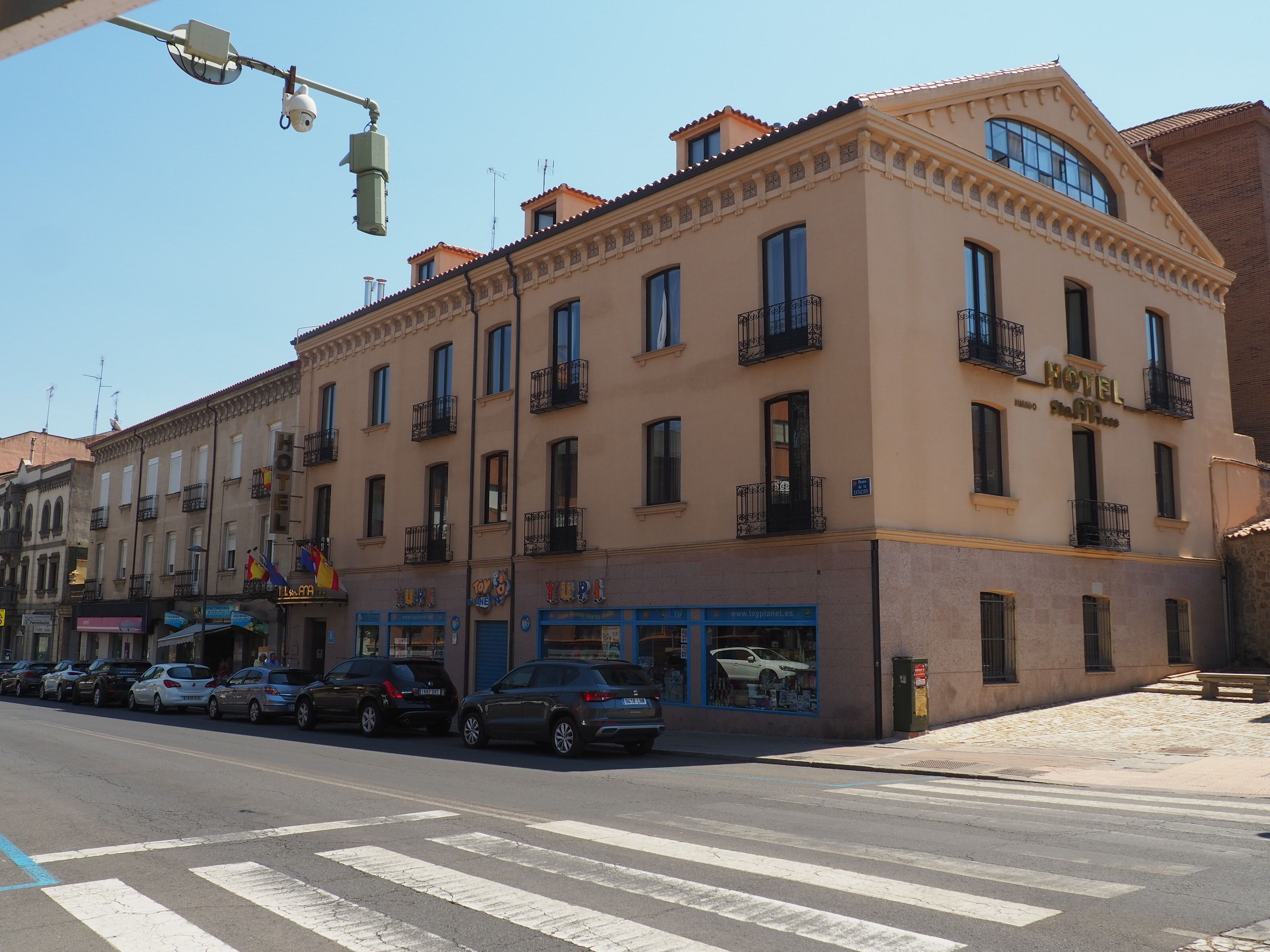 A hotel with multiple floors, balconies, and a storefront with a toy store.