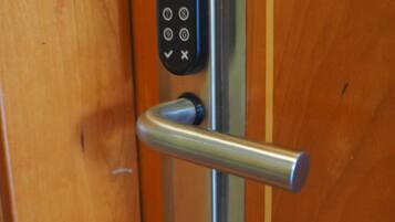 A modern door with a numeric keypad lock and a lever handle.