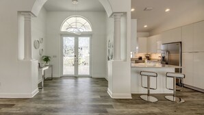 A modern kitchen with a central island, stainless steel appliances, and a large window. - Villa Inspiration - modern style, spectacular view, large pool area  (Cape Coral)