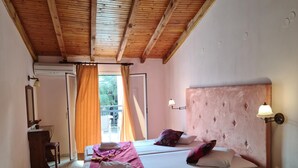 A bedroom with two beds, a wooden ceiling, a bedside table, a nightstand, a lamp, and a window with curtains. - Studio "Galini Studios 2" Near the Beach with Wi-Fi, A/C & Balcony (Corfu)