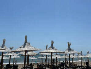 A beach with thatched umbrellas and beach chairs. - Holiday Home La Reserva de Alvarito with Pool, Garden, Terrace & Wi-Fi (Marbella)