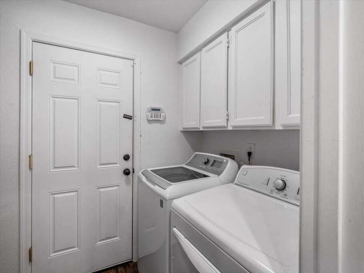 A laundry room with a white door, a washing machine, and a dryer.