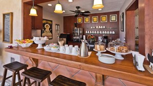 A bar area with a wooden counter, hanging lights, and various food and drink items. - LaMaison Palm Springs (Palm Springs)