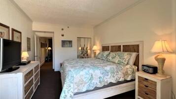 Una habitación de hotel con cama, mesitas de noche, televisor y escritorio.