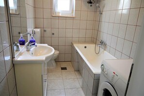 A small bathroom with a sink, toilet, and a bathtub. - Stunning 2-bed Apartment in Okrug Gornji (Okrug)