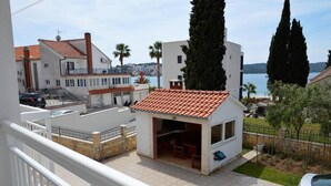 A residential building with a tiled roof, a balcony, and a view of the sea. - Stunning 2-bed Apartment in Okrug Gornji (Okrug)