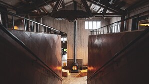 Una escalera de madera que lleva a una zona central con una chimenea.