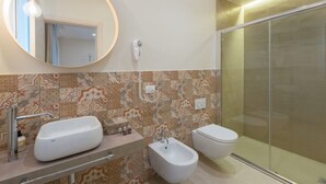 Ein Badezimmer mit zwei Waschbecken, einem Bidet und einer Toilette.
