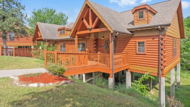 A log cabin with a porch and a small deck. - Peaceful Walk-in Cabin with Whirlpool Tub, Gas Fireplace, and Screened-in Porch (Branson)