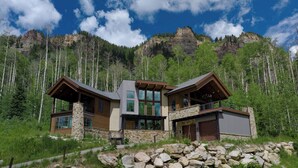 A modern two-story house with a stone foundation, large windows, and a balcony. - One-of-a-Kind Luxury Home - Hot Tub, Firepit, Views - 8 Min to Purg (Durango)