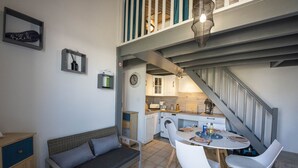 Un espai vital reduït amb zona de cuina, menjador i sofà.