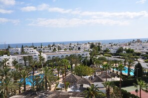 A coastal resort with white buildings, palm trees, and a swimming pool. - Hotel Kanta Resort & Spa (Port El Kantaoui)