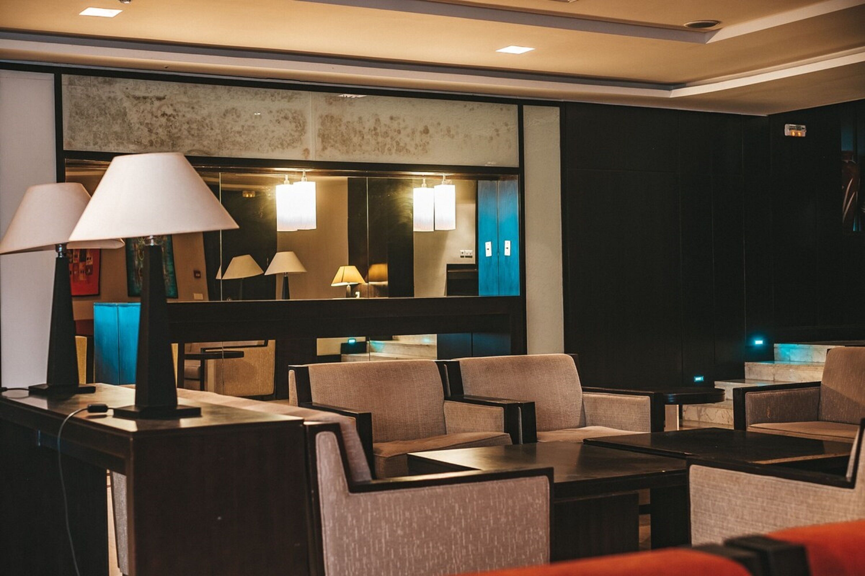Eine moderne Hotelhalle mit Sitzbereichen, Tischen und Lampen.