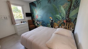Une chambre à coucher avec un lit, une chaise, un bureau et une fenêtre.