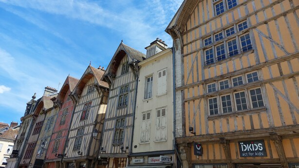 A row of traditional half-timbered buildings with a clear blue sky above.