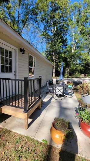 A covered patio with outdoor furniture, a wooden deck, and potted plants. - #3 Cabin at Red Oak Valley (Canaan Township)