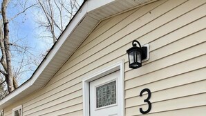 A house with a white door, a black mailbox, and the number 3 on the wall. - #3 Cabin at Red Oak Valley (Canaan Township)
