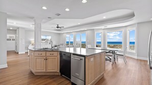 A spacious kitchen with a large island, built-in appliances, and a view of the ocean. - Gulf Front Beach House | Pet Friendly | Panoramic Coastal Views (Gulf Shores)