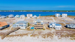 A coastal residential area with beachfront properties, including houses with balconies and a swimming pool.
