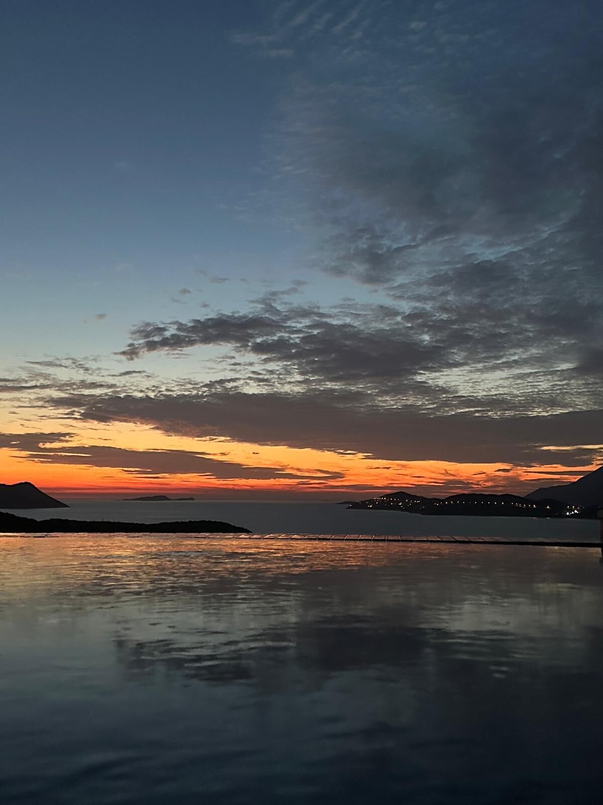 Un cuerpo de agua tranquila reflejando el cielo al atardecer.