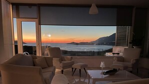 Un salon moderne doté d’une grande porte vitrée donnant sur un balcon offrant une vue imprenable sur l’océan.