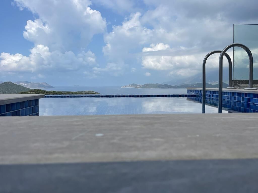 Una piscina infinita con vistas despejadas al mar y a islas distantes.