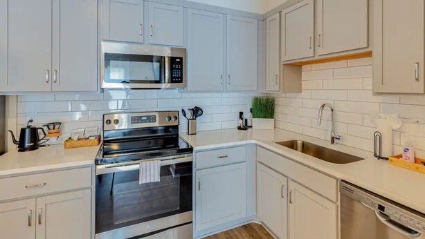 A modern kitchen with white cabinets, stainless steel appliances, and a white countertop. - Welcome to #BestStayEver Nashville/Old Hickory TN (Nashville)