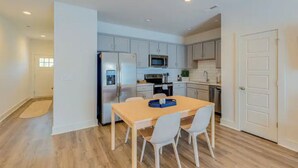 A modern kitchen with white cabinets, a stainless steel refrigerator, a microwave, and a dining table with chairs. - Welcome to #BestStayEver Nashville/Old Hickory TN (Nashville)