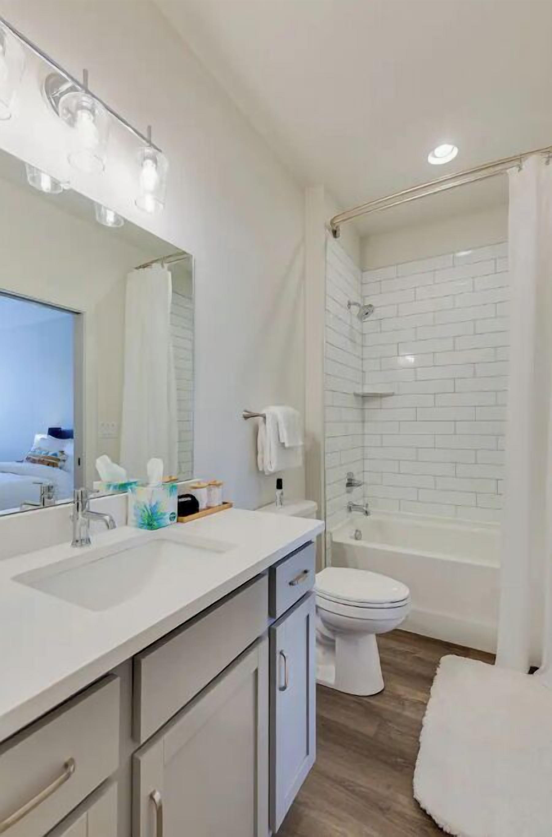 Une salle de bain moderne avec un grand miroir, un lavabo, des toilettes et un espace douche.