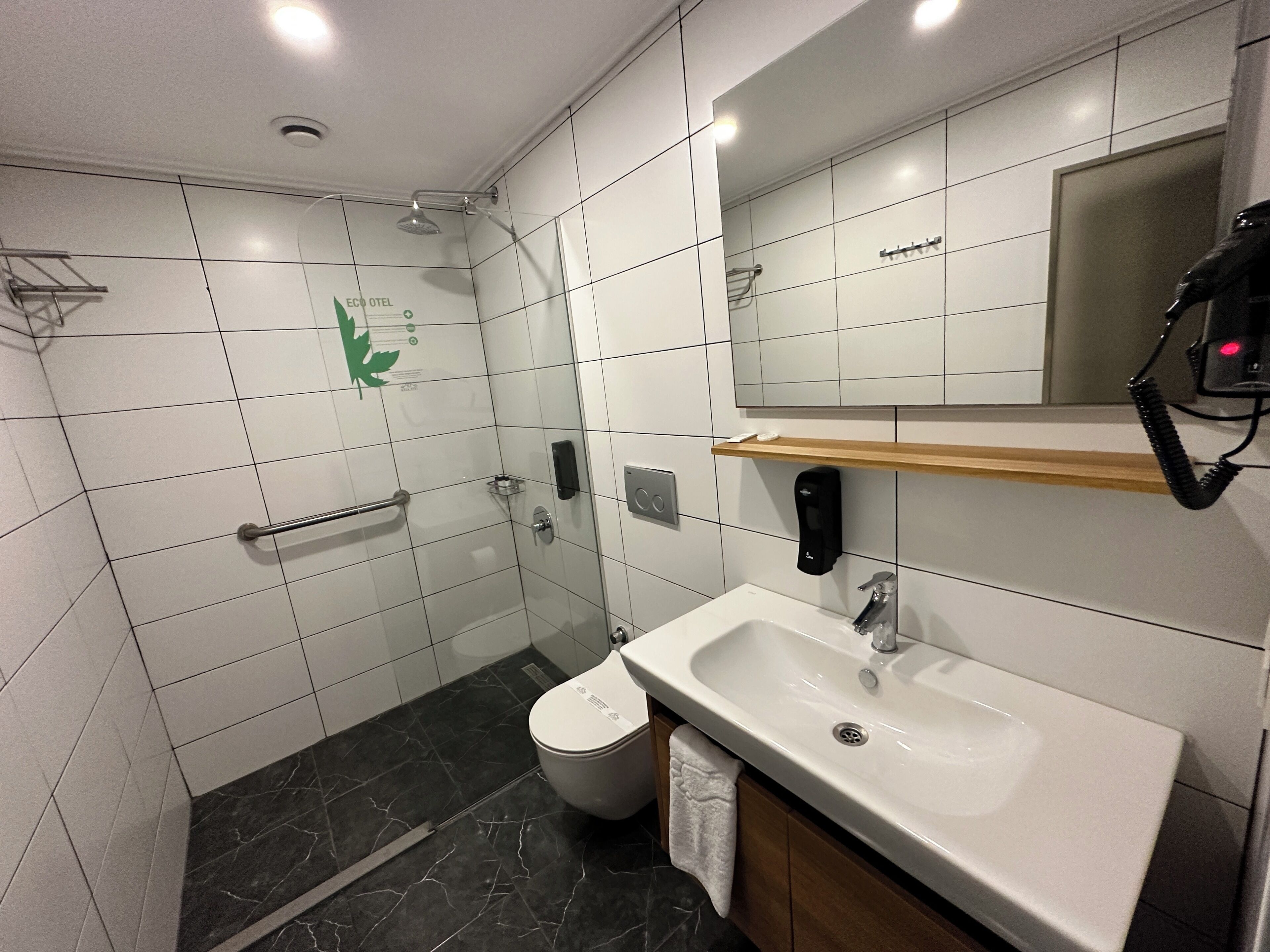 Un baño moderno con ducha, inodoro y lavamanos.