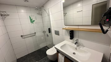 Un baño moderno con ducha, inodoro y lavamanos.