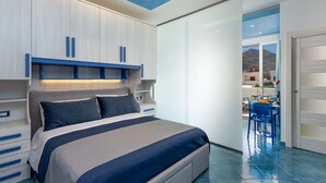A modern bedroom with a large bed, built-in cabinets, and a view of the outside.